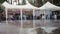 Defocused: Group of people celebrating and partying in tents outdoors during pouring rain