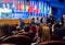 Defocused image. People in the auditorium. International conference. Flags of different countries on stage