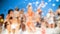 Defocused image of young people dancing on the sea beach at soap foam disco party.