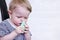 A defocused infant uses a nasal aspirator into the nose, sucking out the mucus. Cleansing snot in a child. Copy space -