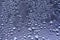 Defocused macro abstract art texture of window condensation with blue hued water drops