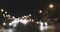 Defocused night traffic lights. Bluured cars lights dividing in two streams, pan left footage