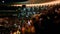 Defocused photo of people listening and watching big rock concert on music festival at big stadium. Crowd of fans