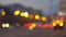 Defocused picture of the evening city lights. Busy road with lots of cars.