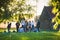 Defocused picture of young people celebrating the end of the school year making a picnic amid poplar fluff in Kolomenskoye public