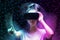 Defocused portrait of young caucasian woman in VR glasses with reaches hand. Dark neon mesh background. The concept of