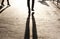 Defocused shadow and silhouette of legs on city sidewalk