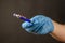 Defocused shot of doctor's hand in blue medical glove with penci