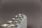 A defocused shot of a line of tin cans. New enclosed Metallic silver individual beverage containers. Selective focus. Noise, blur