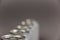 A defocused shot of a line of tin cans. New enclosed Metallic silver individual beverage containers. Selective focus. Noise, blur