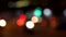 Defocused or soft focus bokeh lights of cars, scooters, motorbikes and traffic driving on city streets at night