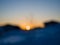 Defocused sunrise. The sun appears over the horizon between wooden houses