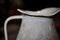 Defocused vintage enamel jug detail in blurred background. Macro