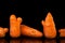 Deformed organic carrots on the black background