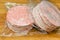 Defrost wrapped frozen burger meat before cooking. On a wooden cutting board on the kitchen table