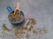 Dehydrated oregano in a bowl with a wooden measuring spoon, top view
