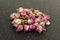 Dehydrated pink rose buds on a black cutting board