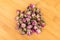 Dehydrated pink rose buds top down view  on a wooden cutting board