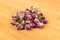 Dehydrated pink rose buds on a wooden cutting board