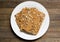 Dehydrated vegan dry raw bread loaves on white dish on wooden table