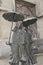 Dei Damen mit Regenschirm mit dem Titel Aachener Wetter, Bronzeskulptur