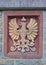 Deisfeld, Germany - August 2nd, 2018 - Heraldic relief in beige on red background depicting an imperial eagle wearing a crown and