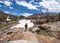 Dejected, injured female hiker walks along the 20 Lakes Basin after hiking through a snow field in summer. Mono County, California