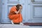 Dejected woman crouching in front of a historic entrance door