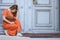 Dejected woman crouching in front of a historic entrance door