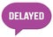 DELAYED text written in a violet speech bubble