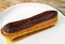 Delectable Chocolate Eclair on a White Plate