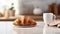 a delectable croissant and a cup of coffee elegantly placed on a kitchen countertop, the scene against a minimalist