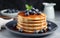 Delectable Pancakes Overflowing with Succulent Blueberries, Harmonizing with Velvety Syrup, Captured on a Stylish Grey Table with