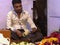 DELHI, INDIA - MARCH 12, 2019: male indian worker making flower garlands in old delhi