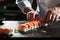 Delicacies in the making: a chef\\\'s hands expertly prepare traditional Japanese sushi rolls