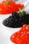 Delicacy black and red caviar macro in white spoons. Vertical
