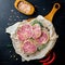 Delicacy sliced beef meatloaf with spiec salt and red pepers on a cutting board. Meat delicacies. Top view and copy