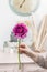 Delicate female hands holding a purple ranunculus flower. Pink chest of drawers in the background. Flower shop, a family