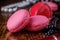 Delicate macaroons of cookies of pink shades on a wooden background.