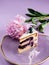 delicate piece of cake on a pink background with pink peony petals