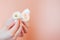 Delicate small roses in hands with a beautiful manicure on a pink background. Soft focus, background image.