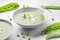 Delicate spring green cream soup with green peas and mint, white background. Spring or summer vibrant healthy vegetarian menu