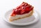 delicate strawberry cheesecake on a white plate. macro