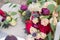 Delicate wedding bouquet with burgundy cream pink roses and feverweed, closeup