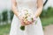 Delicate wedding bouquet in the hands of the bride of roses, freesia, peonies, roses David Austin