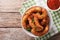 Delicatessen shrimp in coconut breaded closeup in bowl and tomato sauce. horizontal top view