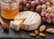 Delicatessen soft fragrant cheese with mold, honey, almonds and red grapes