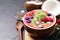 Delicious acai smoothie with granola and fruits served on black table, closeup. Space for text