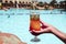 A delicious alcoholic cocktail Sex on the beach in a female hand on the background of the pool