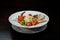 Delicious appetizing Caesar salad with shrimps with tomatoes with boiled chicken egg with cheese with sauce and white bread in a